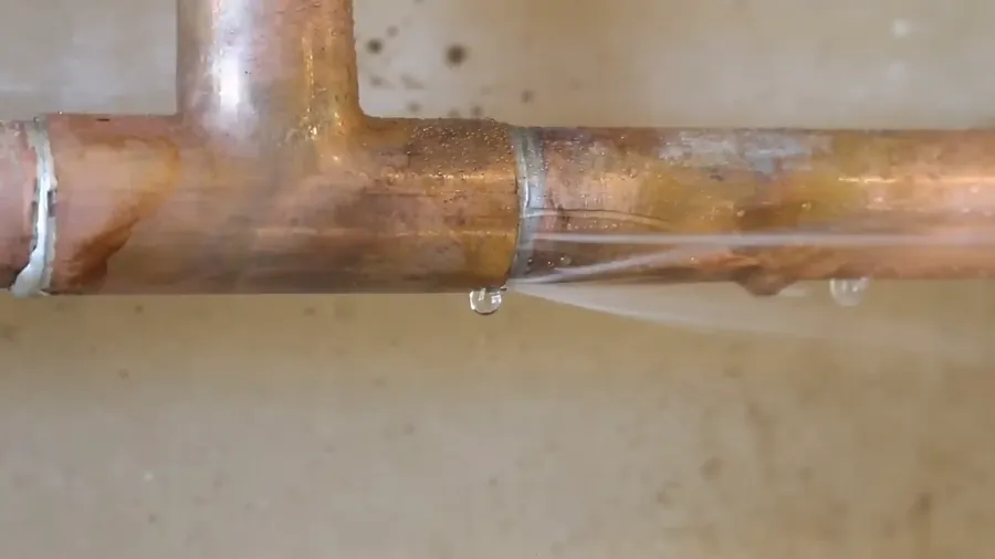 Copper pinhole leak at a joint in a 1980s Tyler TX slab home supply line